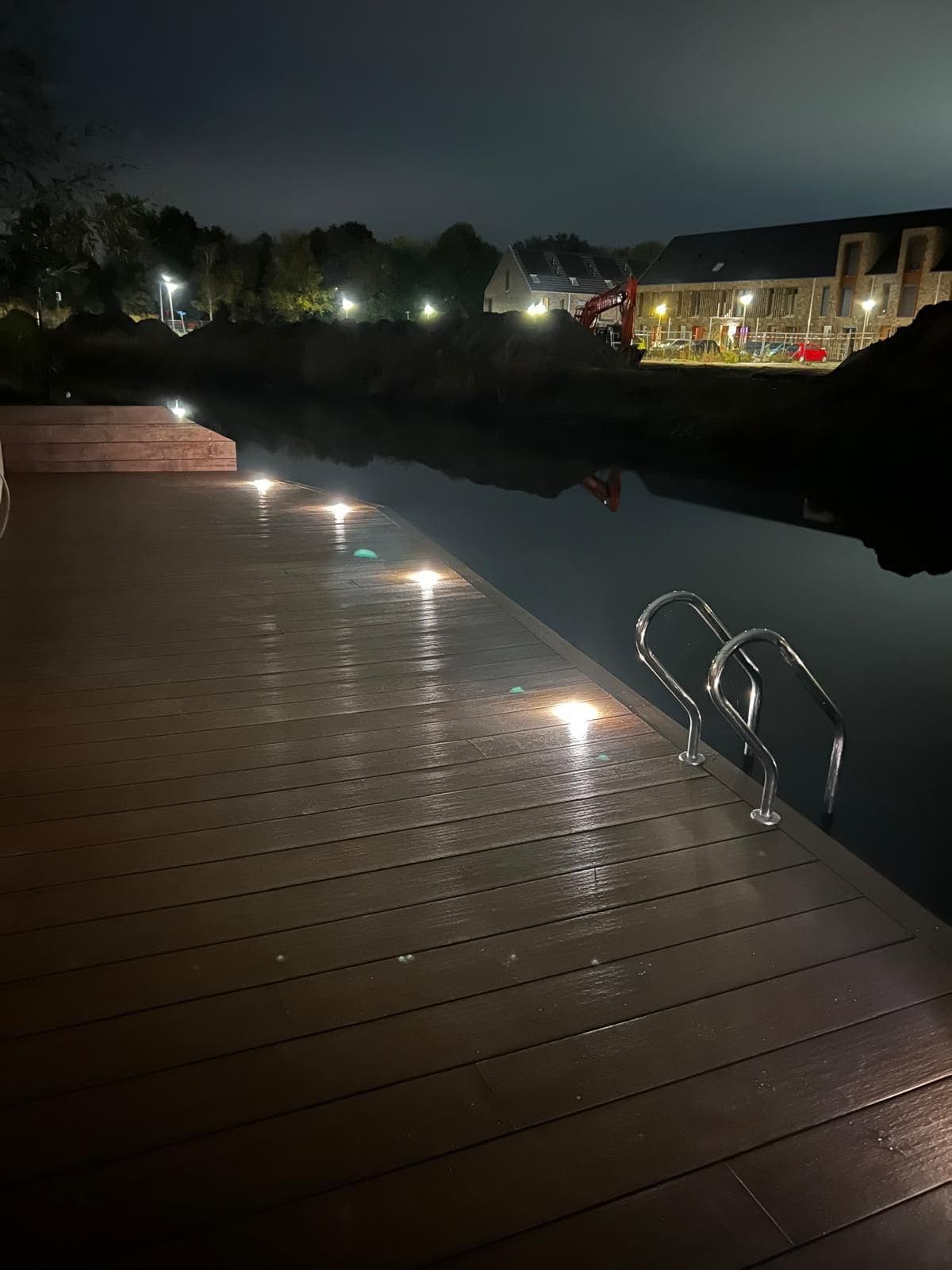 Verlichte vlonder met zwemtrap aan het water