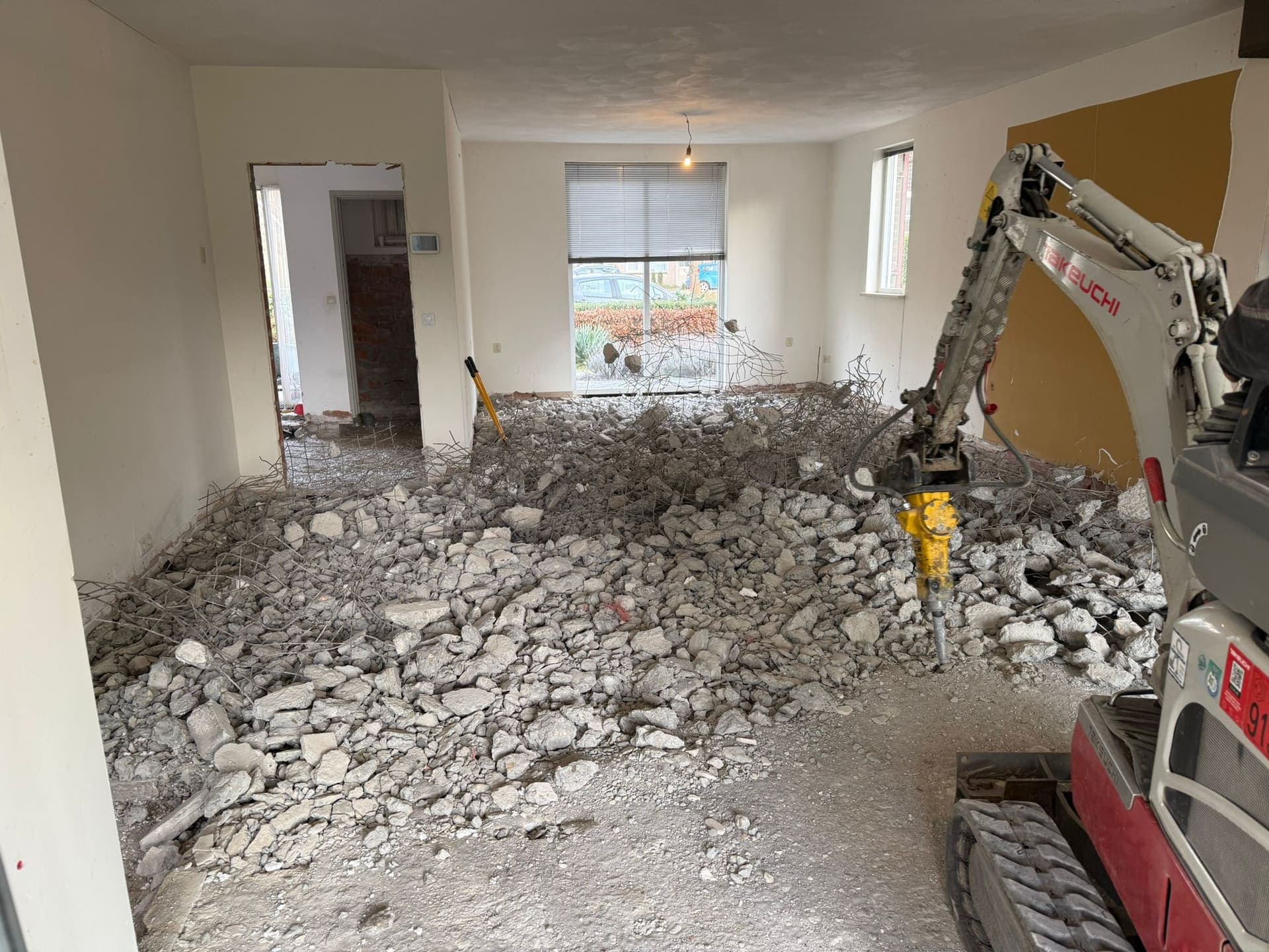 Uitbreken van een oude betonvloer met de minigraver